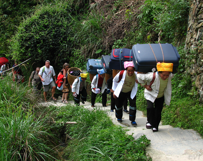 Kofferdraagsters bij de Lijang rijstterrassen