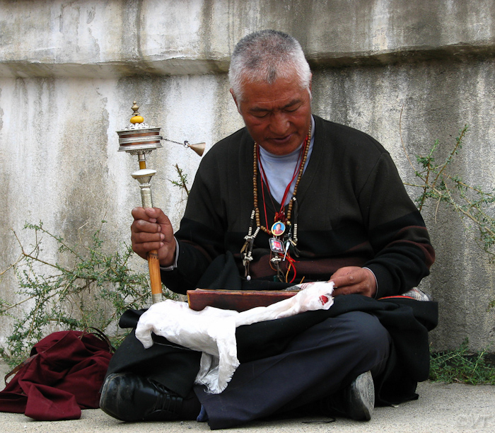 17 biddende monnik met zijn gebedsmolen 